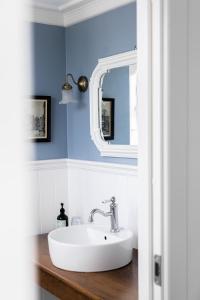 uma casa de banho com um lavatório branco e um espelho. em Arnfeldt Hotel & Restaurant em Ærøskøbing