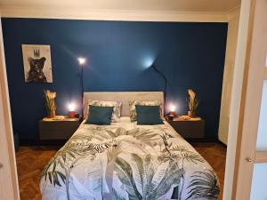 - une chambre avec un grand lit aux murs bleus dans l'établissement Au Pied Du Château, à Bouillon