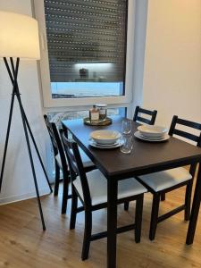 a dining room table with chairs and a table and a lamp at Studio Apartment mit Stellplatz in Bielefeld