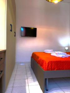 - une chambre avec un lit et une télévision murale dans l'établissement Casa vacanze Casa Elena, à San Giorgio a Cremano