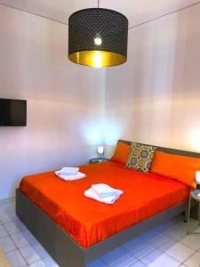 - une chambre avec un lit rouge et des serviettes dans l'établissement Casa vacanze Casa Elena, à San Giorgio a Cremano