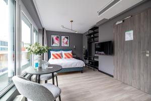 a bedroom with a bed and a table and chairs at numa l Saga Apartments in Bremen