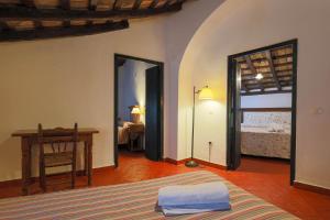 a bedroom with a bed and a desk in a room at Casas Rurales Tugasa Castillo de Castellar in Castellar de la Frontera