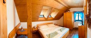 Cama en habitación con techo de madera en Chalupy Betlém Hlinsko, en Hlinsko