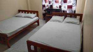 two twin beds in a room withthritisthritisthritisthritisthritisthritisthritisthritisthritis at Samarathunga Guest House in Katunayake