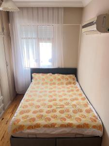 a bed in a small room with a window at Konfor ve huzurunuz için her şey var klimalı oda in Antalya