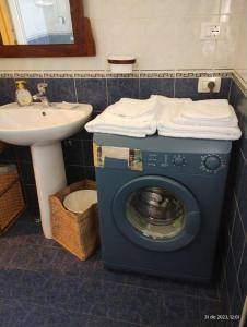 een badkamer met een wasmachine en een wastafel bij Attico luminoso I colori del sole in Montesilvano