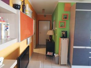 een keuken met groene en oranje muren en een koelkast bij Attico luminoso I colori del sole in Montesilvano