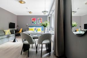 sala de estar con mesa, sillas y sofá en numa l Saga Apartments, en Bremen