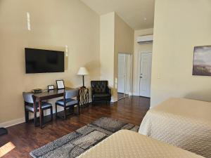 a hotel room with a desk and a bedroom at Sunset Cottage Motel Rooms in Ligonier