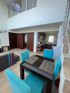 ein Wohnzimmer mit einem Tisch und blauen Stühlen in der Unterkunft Дуплекс 2+1 в Татлысу in Akanthou