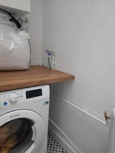 eine Waschküche mit einer Waschmaschine und einer Holztheke in der Unterkunft Maison rénovée-moderne avec cour à 2 pas du centre in Orléans