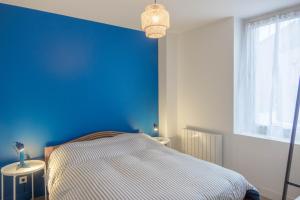 - une chambre avec un mur bleu et un lit dans l'établissement Maison rénovée-moderne avec cour à 2 pas du centre, à Orléans