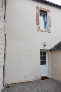 une maison blanche avec une fenêtre et une porte dans l'établissement Maison rénovée-moderne avec cour à 2 pas du centre, à Orléans
