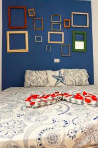 a bed with a blue wall with pictures on it at Casa Carlotta Maio in Vila do Porto