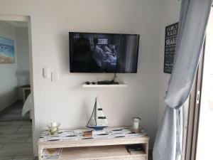 a flat screen tv on a wall with a table at Summer Place 36 in Margate