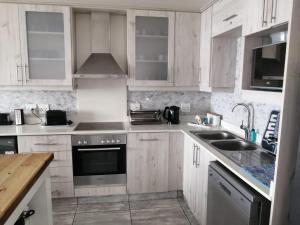 a kitchen with white cabinets and a sink at Summer Place 36 in Margate