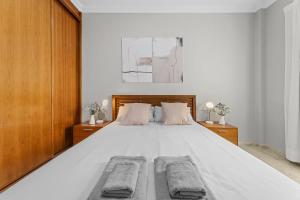 1 dormitorio con 1 cama blanca grande y 2 almohadas en Piso Don Eduardo 2, en Arrecife