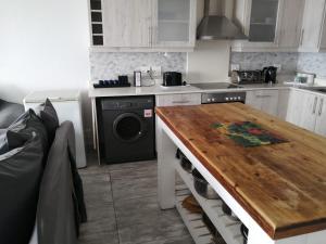 a kitchen with a stove and a wooden table at Summer Place 36 in Margate