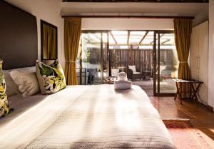 a bedroom with a large bed and a living room at St Francis Golf Lodge in St Francis Bay