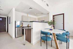 阿布扎比Silkhaus Luxury 1 BDR Close To Reem Central Park的配有桌椅和冰箱的厨房 更多11张照片