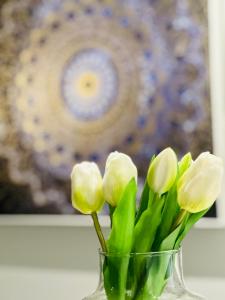 Un jarrón de cristal con flores blancas. en Meliora Suites, en Dhrapaniás