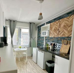 a kitchen with white appliances and a table in it at Ipanema, Train Lens - Paris trajet d'environ 1 heure 10 minutes in Lens