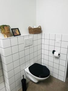a bathroom with a toilet with a black seat at Gastenverblijf 'tsiishokje' in Lioessens +25 photos