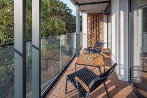 a patio with chairs and a table on a balcony at Apartamenty na Półwyspie Wydma&Las in Jastarnia