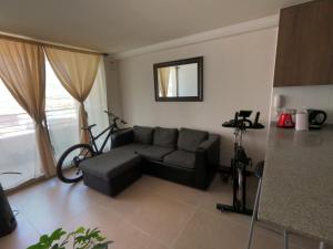 sala de estar con sofá y bicicleta en la pared en El Faro Antofagasta, en Antofagasta
