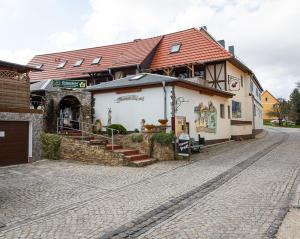 a building on the side of a cobblestone street at Kräuterhotel Garni Zur Klostergrotte in Nohra