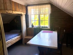 Zimmer mit einem Tisch, einem Bett und einem Fenster in der Unterkunft House by the Sea in Sortland