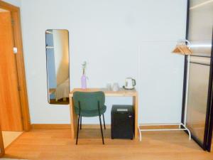 - un bureau avec une chaise verte et un miroir dans l'établissement OLBLANC Plaza de España by Batuecas, à Madrid