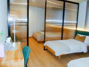 Cette chambre comprend deux lits, un bureau et une table. dans l'établissement OLBLANC Plaza de España by Batuecas, à Madrid