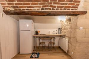 eine Küche mit einem Kühlschrank und einem Tisch mit Stühlen in der Unterkunft La Mazère - Maison atypique avec extérieur in Pocé-sur-Cisse + 10 Fotos