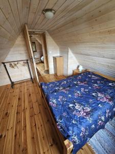 ein Schlafzimmer mit einem Bett in einer Holzhütte in der Unterkunft Agro Rancho domki in Podgórzyn