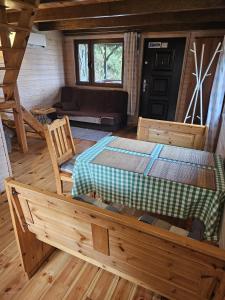 een slaapkamer met een bed en een bank in een hut bij Agro Rancho domki in Podgórzyn