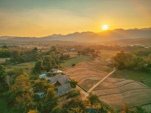 拜縣的住宿－Cody Backpackers，享有农场的空中景色,背景是日落