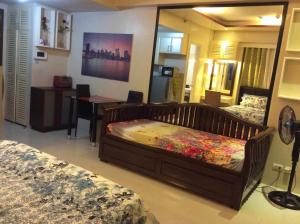 1 Schlafzimmer mit 2 Betten und einem Spiegel in der Unterkunft Palm Tree Villas by Ann in Manila