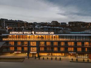 a large building with a sign on top of it at Panorama Lisi Grand Hotel in Tbilisi City