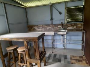 a kitchen with a table and stools and a sink at Chava Camping Rio Celeste in Rio Celeste