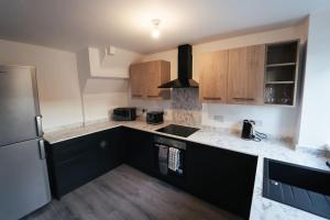 a kitchen with wooden cabinets and a refrigerator at Middlesbrough contractors digs in Middlesbrough