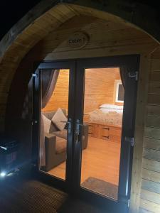 a view of a room with a bed through a glass door at Conifer Cabins in Fort William