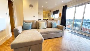 a living room with a couch and large windows at Urban Living with Free Wi-Fi & Parking in Rickmansworth