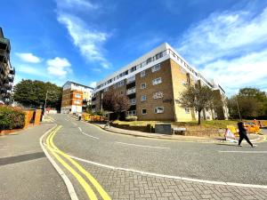 a person walking down a street next to a building at Urban Living with Free Wi-Fi & Parking in Rickmansworth