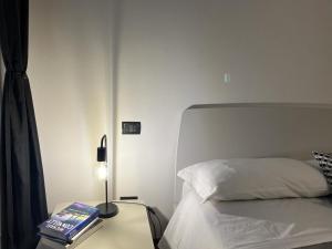 a bedroom with a bed and a table with a lamp at Ophelia Leon Charme&Relax in Bergamo