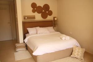 a bedroom with a bed with two towels on it at Mangroovy Gouna 1 BR apartment in Hurghada