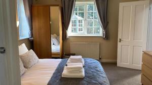 1 dormitorio con 1 cama con toallas en midsummer cottage en Kirby Misperton