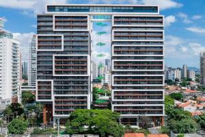 a tall building with umbrellas in front of a city at Habitarte - Studio Luxo Brooklin in São Paulo