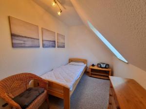 a small bedroom with a bed and a chair at Ferienwohnung Seeigel in Prerow